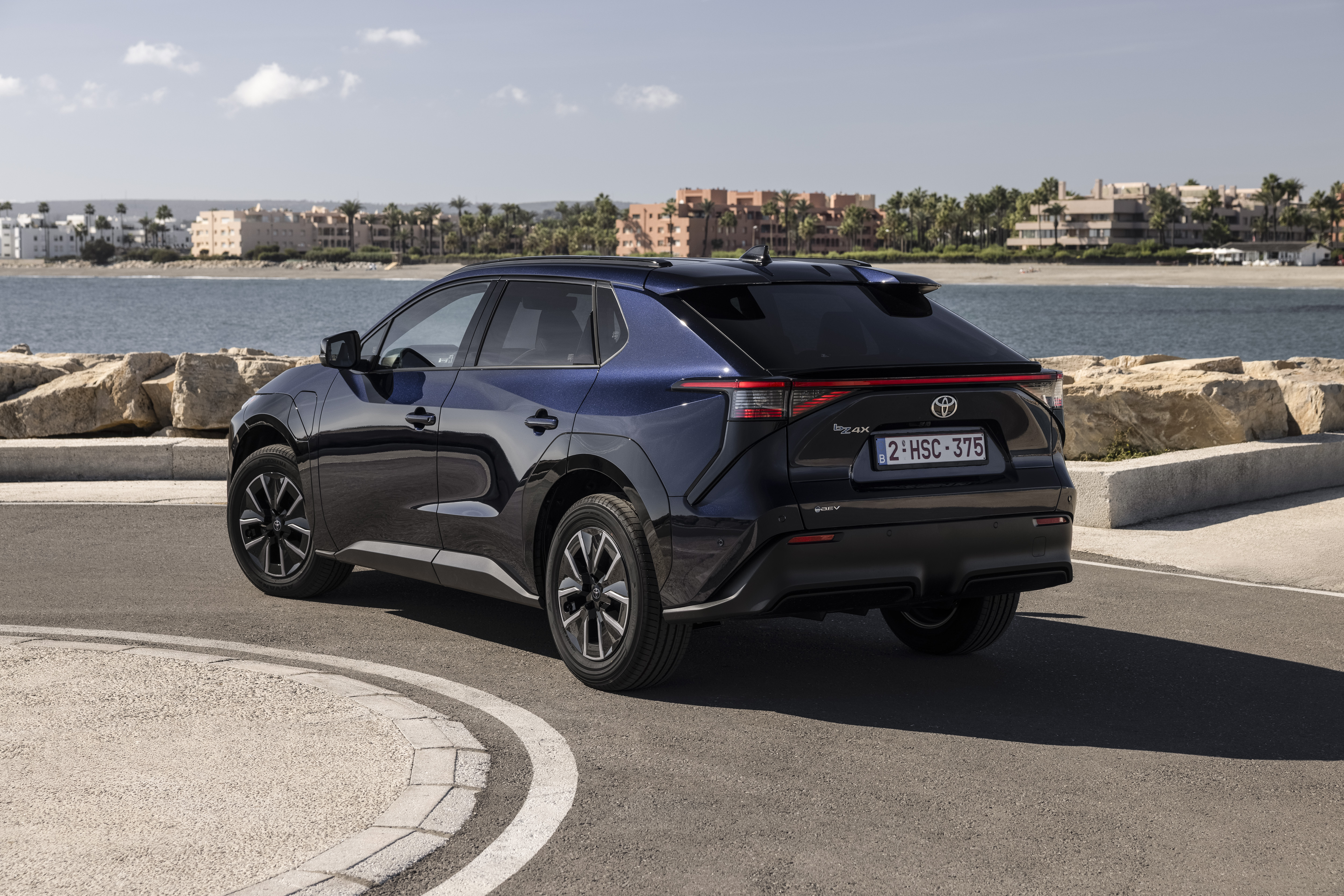 2026 Toyota bZ4X in movimento, vista laterale in blu metallizzato profondo