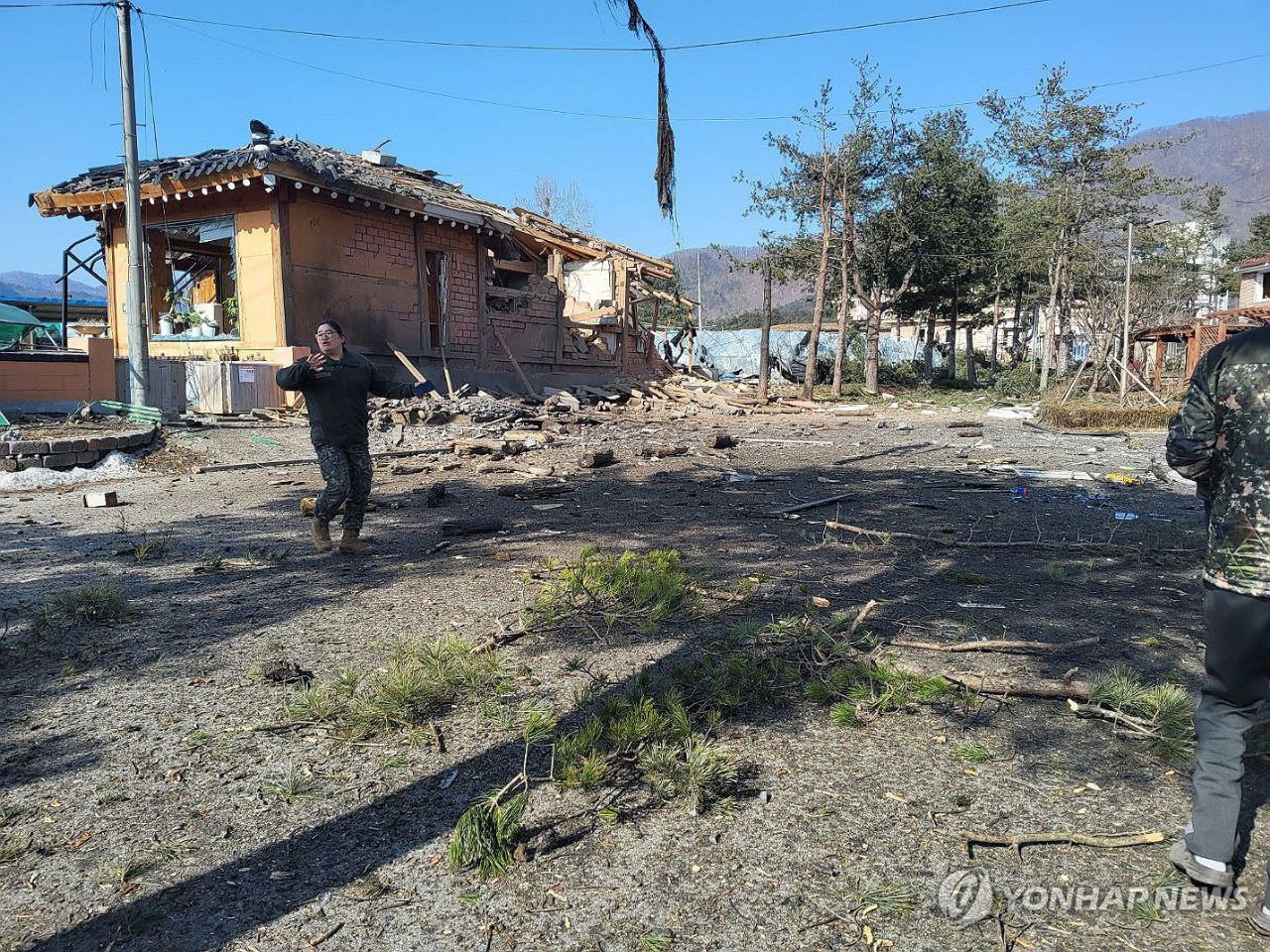 Ufficiali militari ispezionano l'area in cui sono state sganciate le bombe a Pochon Ufficiali militari ispezionano l'area in cui sono state sganciate le bombe a Pochon